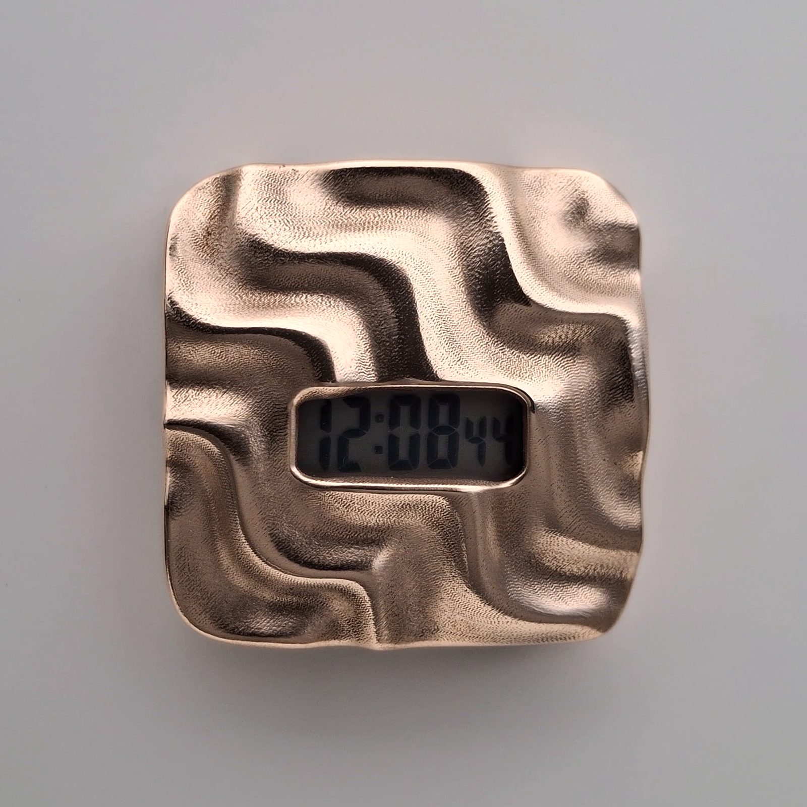 Close view of the bare bronze Askja case and its sculpted waves