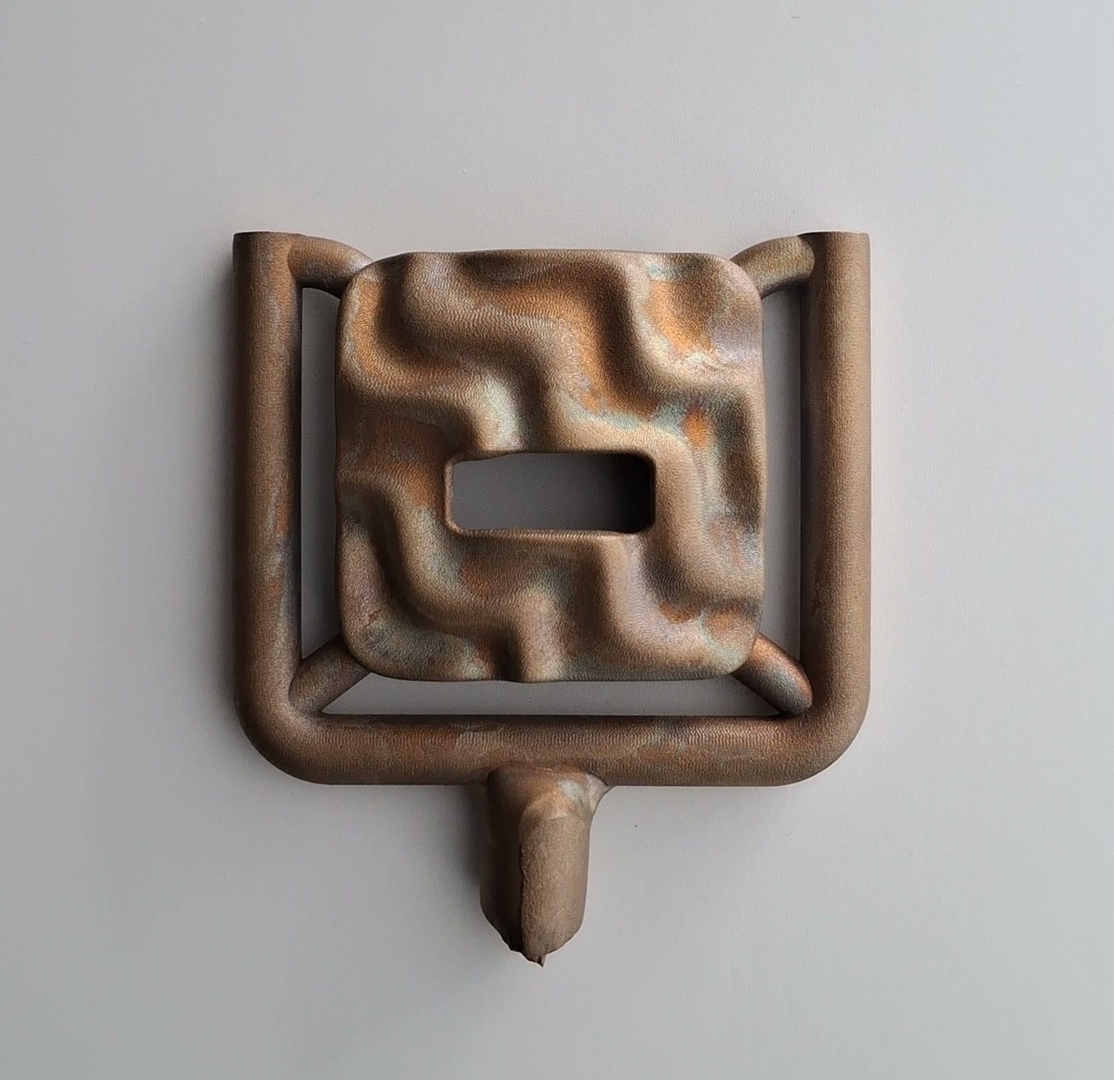 A cast bronze case with the sprue still attached